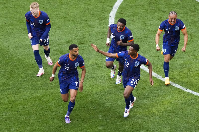 Cody Gakpo of the Netherlands, bottom left, celebrates with teammates after scoring the opening goal during a round of sixteen match between Romania and the Netherlands at the Euro 2024 soccer tournament in Munich, Germany, Tuesday, July 2, 2024. (AP Photo/Frank Augstein)