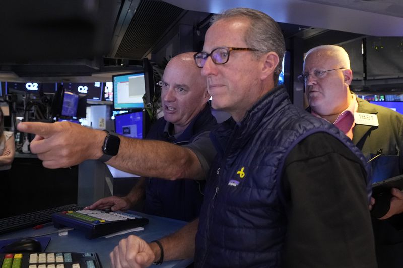 Specialists John O'Hara, left, Glen Carell, center, and trader Thomas Ferrigno work on the floor of the New York Stock Exchange, Friday, Aug. 16, 2024. (AP Photo/Richard Drew)