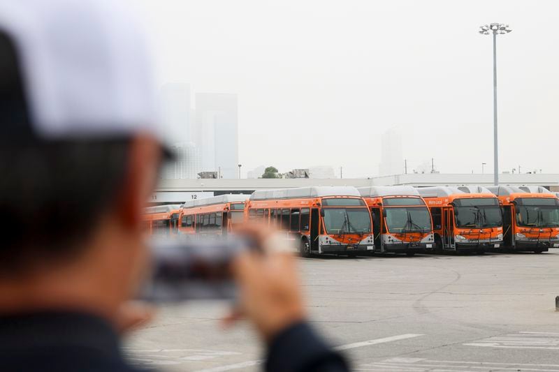 News media prepare to go live in front of a Los Angeles MTA bus depot near the site where overnight a bus was hijacked by an armed subject with passengers on board Wednesday, Sept. 25, 2024, in Los Angeles. One person was fatally shot before police apprehended the suspect. (AP Photo/Ryan Sun)