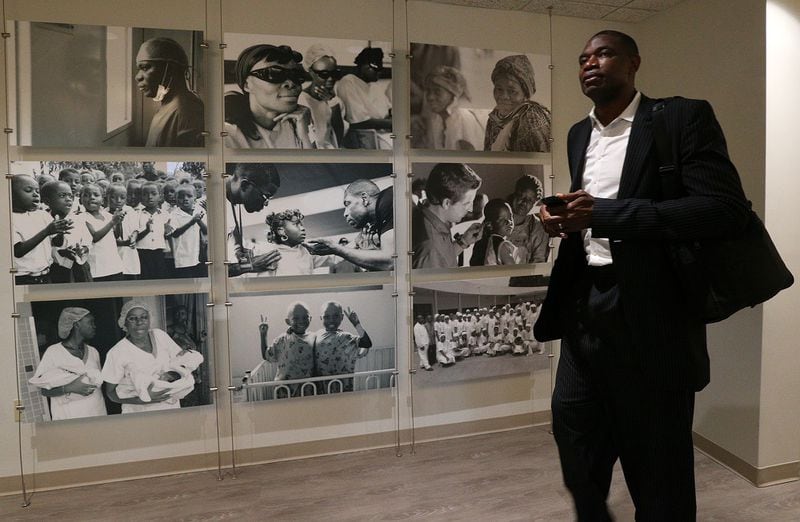 June 7, 2017, Atlanta: Dikembe Mutombo walks past photos from the Biamba Maria Mutombo Hospital in Kinshasa leaving his office at the end of the work day at the Dikembe Mutombo Foundation, Inc., on Wednesday, June 7, 2017, in Atlanta.     Curtis Compton/ccompton@ajc.com