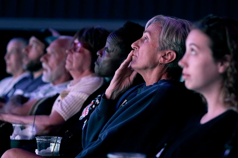 People watch the presidential debate between Republican presidential nominee former President Donald Trump and Democratic presidential nominee Vice President Kamala Harris at a 97-year-old movie theater Tuesday, Sept. 10, 2024, in Shawnee, Kan. (AP Photo/Charlie Riedel)