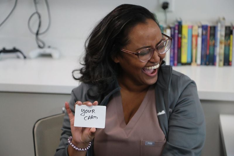 A medical resident laughs as she shows her "card" during a performance by volunteer magicians at the Memorial Health Dwaine and Cynthia Willett Children’s Hospital of Savannah.