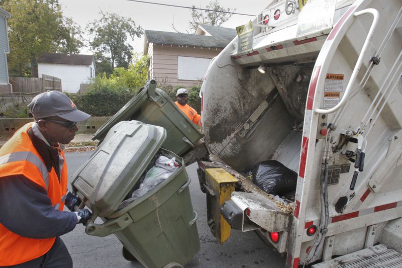 James Dent III (in back), and Derrick Shelton work a collection route in Atlanta. Bob Andres / bob.andres@ajc.com