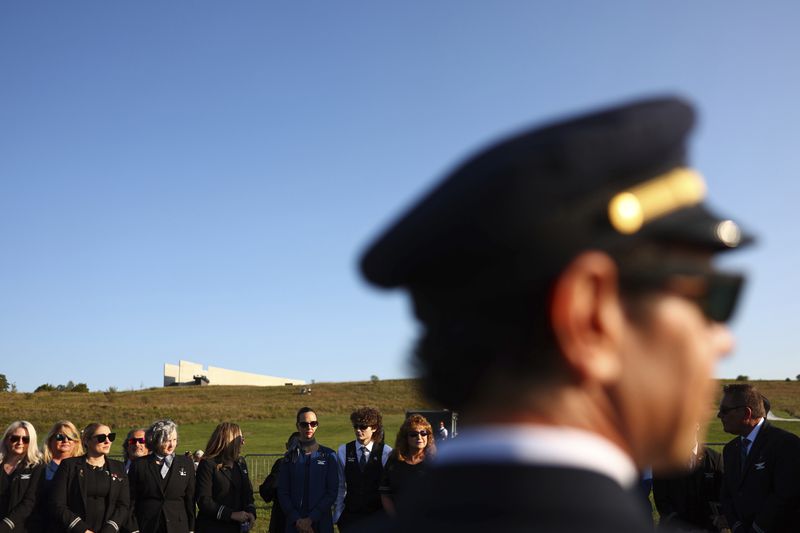 Airline employees pause at the Flight 93 National Memorial on the 23rd anniversary of the Sept. 11, attacks in Shanksville, Pa., Tuesday, Sept. 11, 2024. (AP Photo/Jared Wickerham)