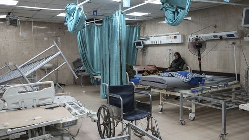 A woman sits on a bed in a room of the Al-Aqsa Martyrs hospital in Deir al Balah, Gaza Strip, Sunday, Aug. 25, 2024. (AP Photo/Abdel Kareem Hana)