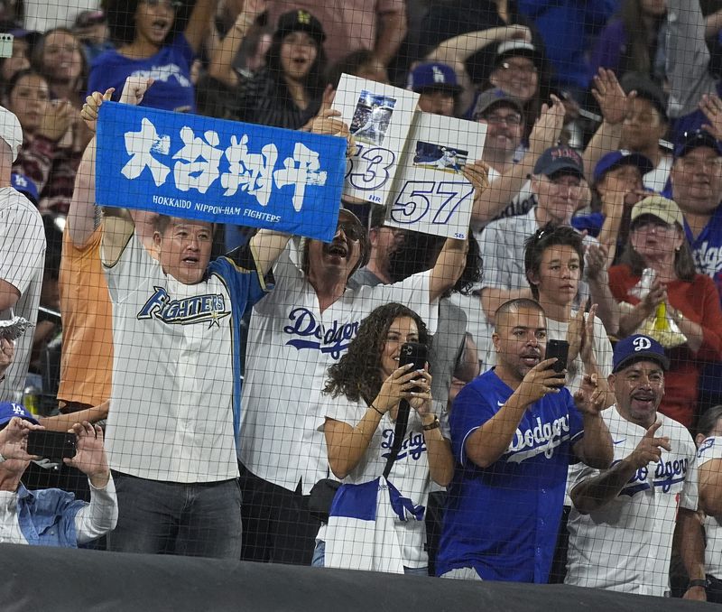 Fans celebrate as Los Angeles Dodgers' Shohei Ohtani circles the bases after hitting a three-run home run off Colorado Rockies relief pitcher Anthony Molina in the sixth inning of a baseball game Friday, Sept. 27, 2024, in Denver. (AP Photo/David Zalubowski)