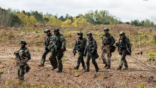 A police team walks through a land swap area near Intrenchment Creek Park in Atlanta on Monday, March 27, 2023. Agencies from across metro Atlanta, along with state agencies, were conducting a clearing operation of Intrenchment Creek Park led by DeKalb County Police. (i(Arvin Temkar / arvin.temkar@ajc.com)