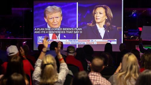 Republican attendees cheer former President Donald Trump during a Sept. 10 presidential debate watch party at gun store and indoor shooting range Adventure Outdoor in Smyrna. (Arvin Temkar/The Atlanta Journal-Constitution)