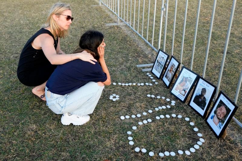 Two women console each other after making a makeshift memorial as members of the Jewish community gather to mark the anniversary of the Oct. 7, 2023, attack at a park in Sydney, Australia, on Monday, Oct. 7, 2024. (AP Photo/Rick Rycroft)