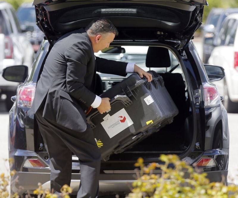 Scott Tucker from Dominion Voting unloads equipment for his presentation in August 2018 in Grovetown. Voting machine companies demonstrated their products at a meeting of then-Secretary of State Brian Kemp’s Secure, Accessible & Fair Elections Commission, which evaluated whether to switch from electronic voting machines to ones that offer paper ballots for verification and auditing. Vendors who attended the meeting included Clear Ballot, Unisyn Voting Solutions, Smartmatic, Election Systems & Software, Hart InterCivic and Dominion Voting. BOB ANDRES /BANDRES@AJC.COM