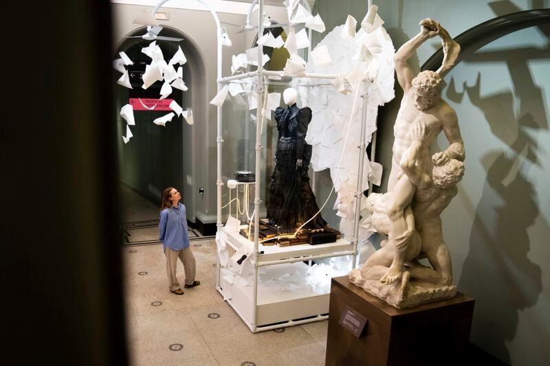 A member of staff views exhibits from previous concert tours that are displayed at the 'Taylor Swift Songbook Trail Exhibition' at the Victoria & Albert Museum, on Wednesday, July 24, 2024 in London. (Photo by Scott A Garfitt/Invision/AP)