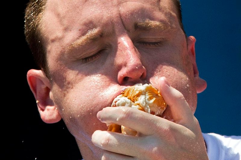 FILE - Five-time reigning champion Joey Chestnut competes in the Nathan's Famous Hot Dog Eating World Championship, July 4, 2012, at Coney Island, in the Brooklyn borough of New York. Chestnut will take his hot dog-downing talents to an army base in Texas for America's Independence Day this year, after a falling out with organizers of the annual New York City-based event. (AP Photo/John Minchillo, File)