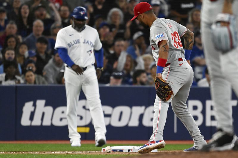 Philadelphia Phillies third baseman Edmundo Sosa (33) watches as a baseball off the bat of Toronto Blue Jays' Alejandro Kirk, not pictured, rolls down the third base line, staying fair for a single in the fifth inning of a baseball game in Toronto on Tuesday Sept. 3, 2024. (Jon Blacker/The Canadian Press via AP)