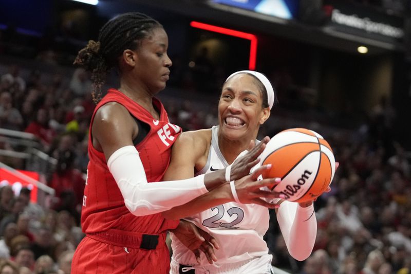 Las Vegas Aces' A'ja Wilson (22) goes to the basket against Indiana Fever's Temi Fagbenle (14) during the second half of a WNBA basketball game, Wednesday, Sept. 11, 2024, in Indianapolis. (AP Photo/Darron Cummings)