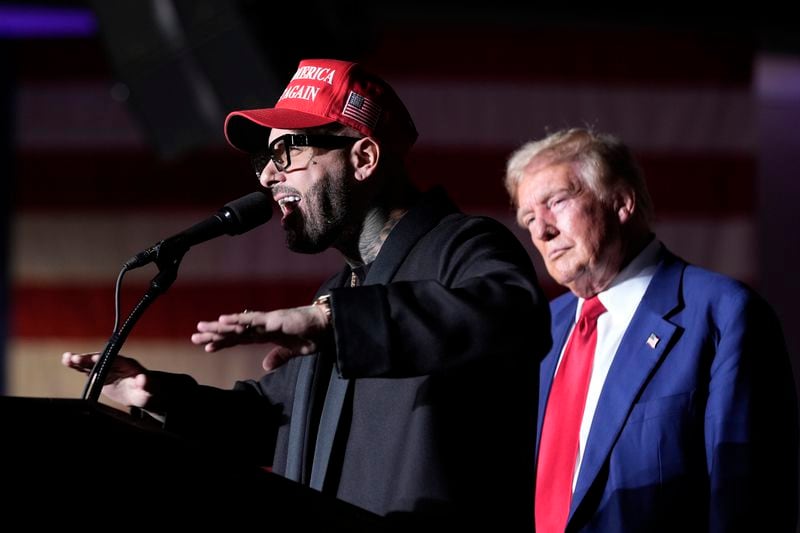 Nicky Jam speaks as Republican presidential nominee former President Donald Trump listens during a campaign event at the World Market Center, Friday, Sept.13, 2024, in Las Vegas. (AP Photo/Alex Brandon)