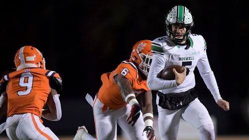 Roswell quarterback Robbie Roper (5) is chased out of bounds by the North Cobb defense in the second quarter Friday, Nov. 19, 2021 at North Cobb High School. (Daniel Varnado/ For the Atlanta Journal-Constitution)