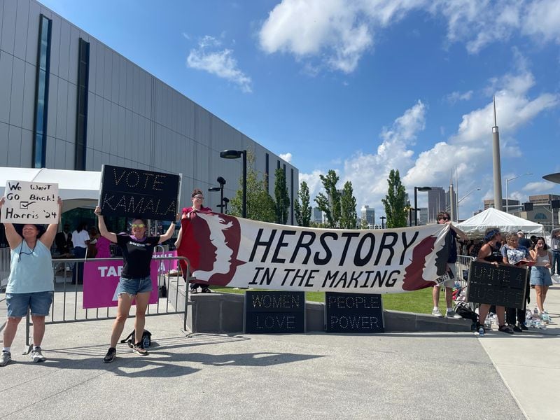 A group of Kamala Harris supporters gathered at the entrance of the rally in Atlanta on Tuesday, July 30, 2024, with a banner that read “Herstory in the making.” (Photo: Riley Bunch / AJC)