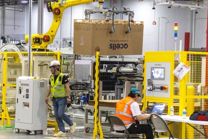 Workers fine-tune the packaging and shipment portion of the automated system at the Qcells module production facility in Cartersville on Tuesday, April 2, 2024.  (Steve Schaefer/steve.schaefer@ajc.com)