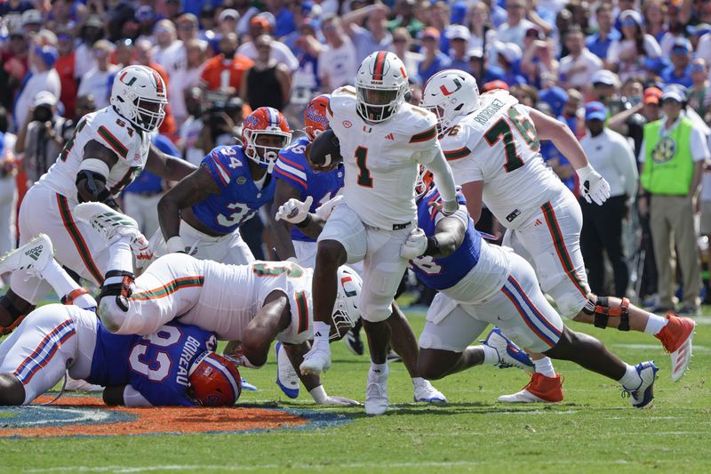 Miami quarterback Cam Ward (1) runs past the Florida defense for yardage during the first half of an NCAA college football game, Saturday, Aug. 31, 2024, in Gainesville, Fla. (AP Photo/John Raoux)