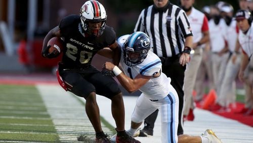 GAC running back Gannon Hearst (20) runs against Lovett defensive back Collin Goldberg (1) in the first half of Friday's game. (Jason Getz/Special to the AJC)