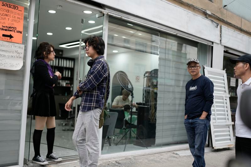 Neighbors walk in front of a hairdresser's in Viaducto Piedad in Mexico City, Wednesday, July 24, 2024. (AP Photo/Eduardo Verdugo)