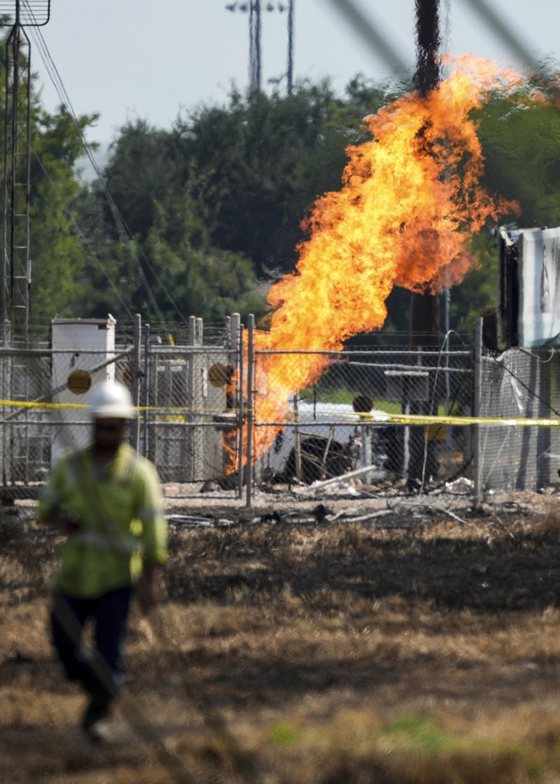 An above-ground valve continues to burn three days after after a vehicle drove through a fence along a parking lot and struck the site, Wednesday, Sept. 18, 2024, in La Porte, Texas. (Jason Fochtman/Houston Chronicle via AP)