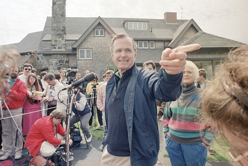 FILE - Vice President George Bush fields a question during a news conference in front of his Kennebunkport, Maine, home, May 27, 1988, with his wife, Barbara, right. (AP Photo/Pat Wellenbach, File)