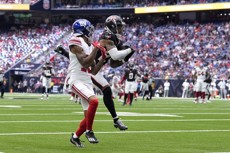 Houston Texans cornerback Derek Stingley Jr., right, intercepts a pass intended for New York Giants wide receiver Jalin Hyatt (13) that was thrown by quarterback Daniel Jones (8) in the first half of a preseason NFL football game, Saturday, Aug. 17, 2024, in Houston. (AP Photo/Eric Gay)