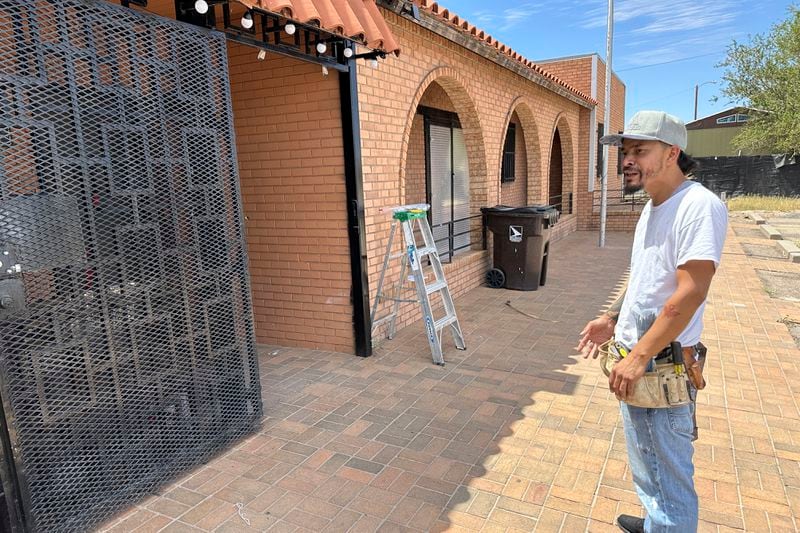 Luis Soto of Sunland Park, N.M. works on wiring and talks outside at his cannabis dispensary, Sunshine Essentials, Thursday, Aug. 22, 2024. The politics of immigration look different from communities on the Southwest border that are voting in hotly contested congressional races. Soto said migrants who cross the border have impacted his efforts to open the cannabis dispensary in a former small-town post office. He's a registered Democrat who remembers better economic times under former President Donald Trump. (AP Photos/Morgan Lee)