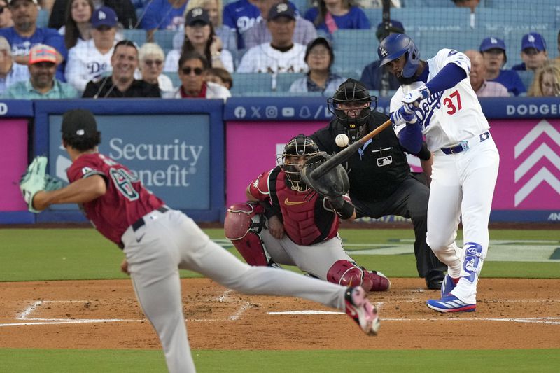 Los Angeles Dodgers' Teoscar Hernández, right, hits a solo home run as Arizona Diamondbacks starting pitcher Cristian Mena, left, and catcher Gabriel Moreno, second from left, watch along with home plate umpire Jordan Baker during the first inning of a baseball game Wednesday, July 3, 2024, in Los Angeles. (AP Photo/Mark J. Terrill)