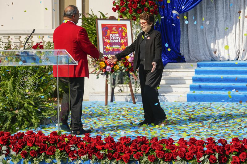 Tennis legend Billie Jean King is greeted by Tournament of Roses President Ed Morales at an event to introduce King as grand marshal of the 136th Rose Parade next year on the front steps of the Tournament House in Pasadena, Calif., Monday, Oct. 7, 2024. (AP Photo/Damian Dovarganes)