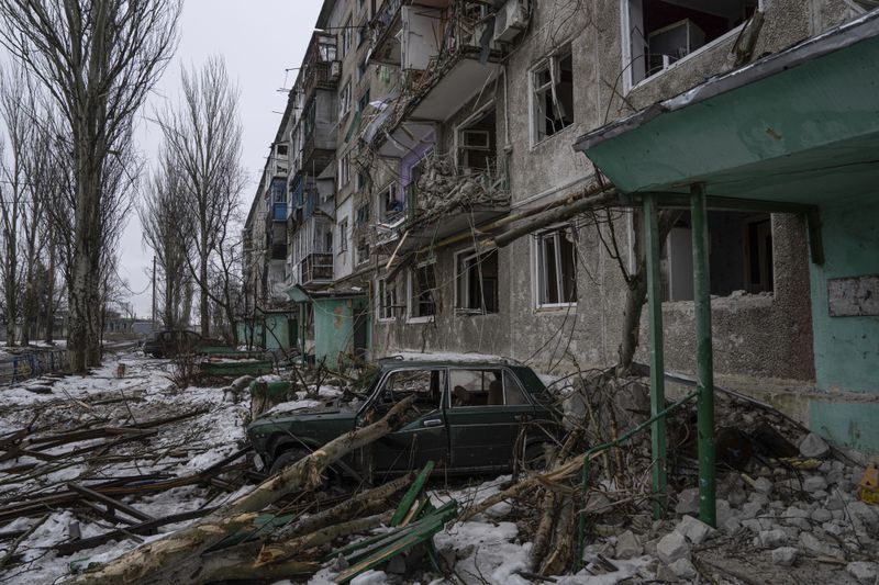 FILE - A destroyed car is seen in front of a residential building which was heavily bombed by Russian forces, in the frontline city of Vuhledar, Ukraine, Feb. 25, 2023. (AP Photo/Evgeniy Maloletka, File)