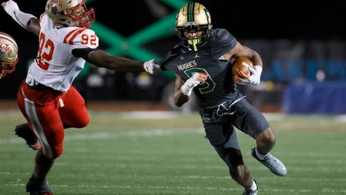 Langston Hughes running back Jekail Middlebrook (9) runs for yards as Rome defensive lineman Tyson Brown (92) grabs his shirt during the first half in the Class 6A semi-final at Lakewood Stadium, Friday, December 2, 2022, in Atlanta. Jason Getz / Jason.Getz@ajc.com)
