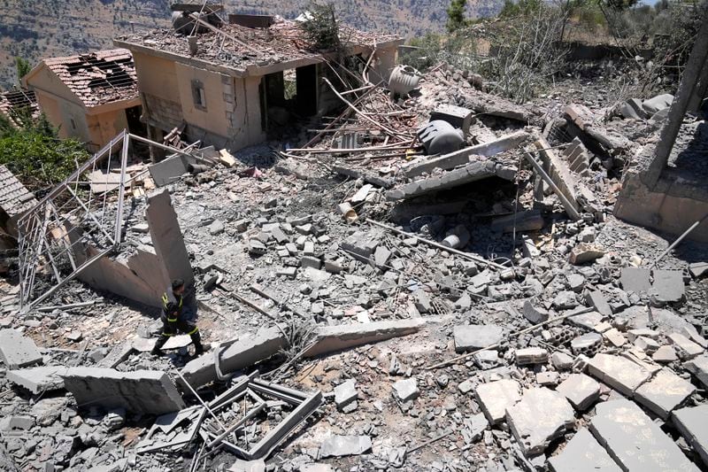 FILE - A civil defense worker inspects destroyed houses that were hit by an Israeli airstrike, in Chebaa, a Lebanese town near the border with Israel, south Lebanon, June 26, 2024. (AP Photo/Hussein Malla, File)