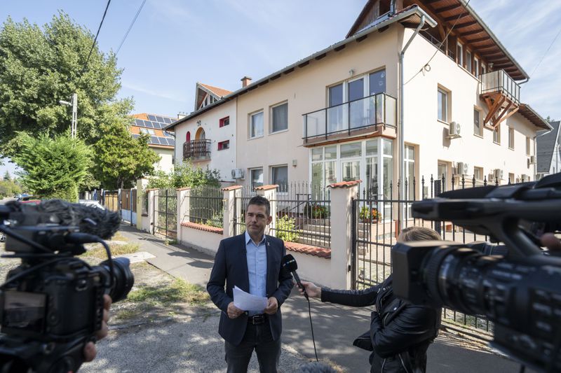 Előd Novak, a member of the National Assembly of Hungary, talks to the local media in front of a house where a Hungarian company that allegedly manufactured pagers that exploded in Lebanon and Syria, is headquartered in Budapest Wednesday, Sept. 18, 2024. (AP Photo/Denes Erdos)