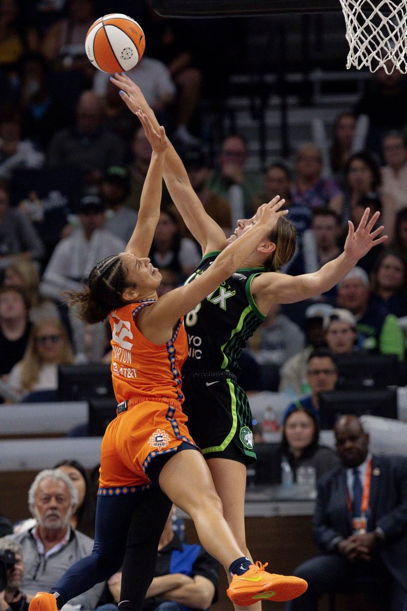 Minnesota Lynx forward Alanna Smith (8) blocks a shot by Connecticut Sun guard Veronica Burton (22) during the first half of Game 1 of a WNBA basketball semifinals series Sunday, Sept. 29, 2024, in Minneapolis. (AP Photo/Stacy Bengs)