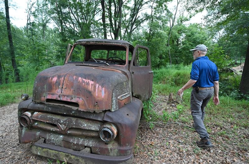 Abandoned vehicles on the grounds of the Rockdale Art Farm have been immortalized in paintings that hand in the office. (Hyosub Shin / AJC)