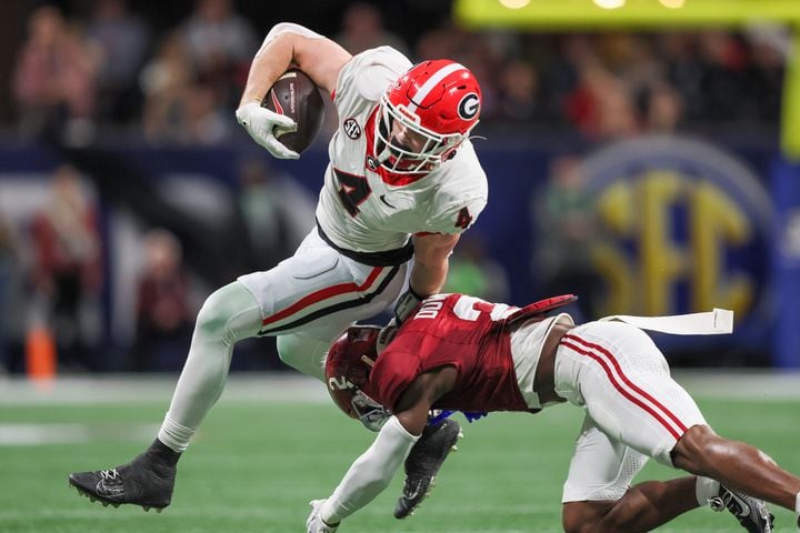 Georgia Bulldogs tight end Oscar Delp (4) is stopped by Alabama Crimson Tide defensive back Caleb Downs (2) during the first half of the SEC Championship football game at the Mercedes-Benz Stadium in Atlanta, on Saturday, December 2, 2023. (Jason Getz / Jason.Getz@ajc.com)