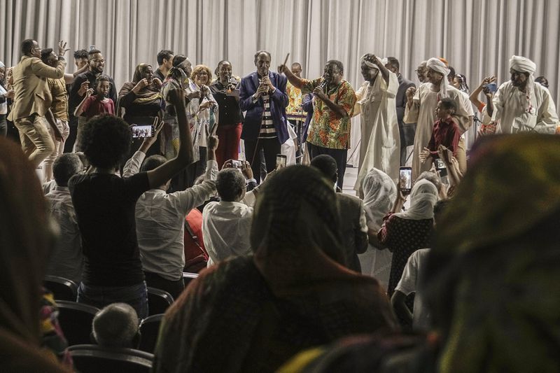 Sudanese Camirata troupe founder Dafallah el-Hag, center, greets Sudanese and foreign audience at the end of a show at the Russian culture center in Cairo, Egypt, Sunday, Sept. 15, 2024. (AP Photo/Amr Nabil)