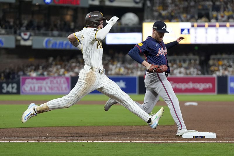 San Diego Padres' Jackson Merrill, left, is out at first base on a ground ball behind Atlanta Braves relief pitcher Aaron Bummer during the fourth inning in Game 1 of an NL Wild Card Series baseball game Tuesday, Oct. 1, 2024, in San Diego. (AP Photo/Gregory Bull)