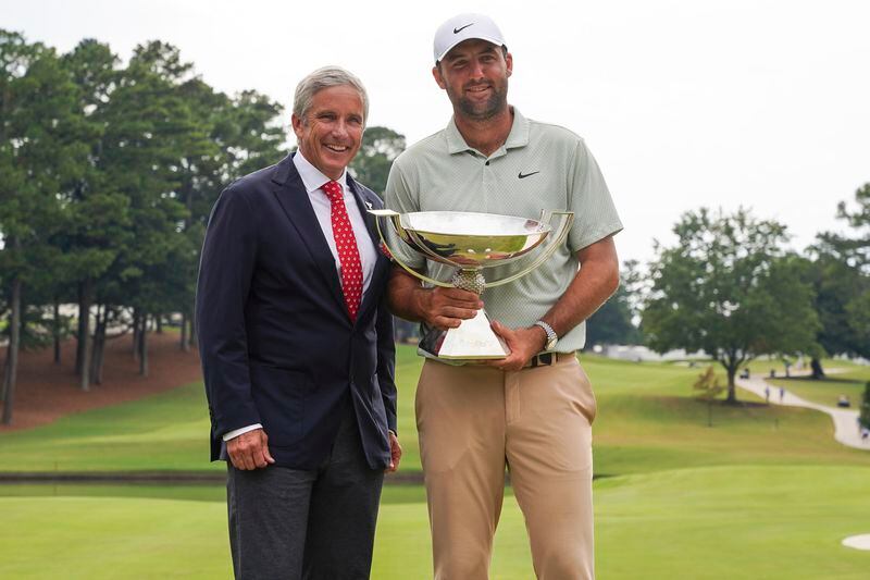 PGA TOUR Commissioner Jay Monahan poses with Scottie Scheffler with the FedExCup Trophy after Scheffler won the final round of the Tour Championship golf tournament, Sunday, Sept. 1, 2024, in Atlanta. (AP Photo/Jason Allen)