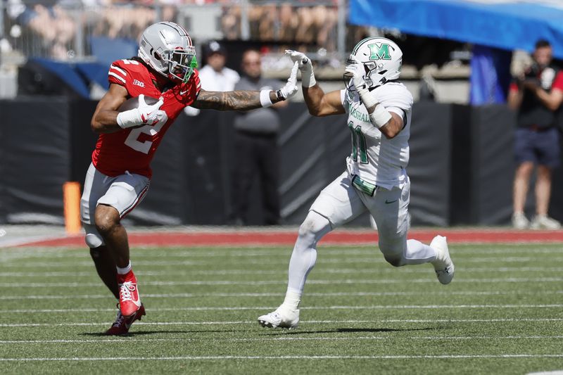 Ohio State receiver Emeka Egbuka, left, tries to stiff arm Marshall defensive back J.J. Roberts during the first half of an NCAA college football game Saturday, Sept. 21, 2024, in Columbus, Ohio. (AP Photo/Jay LaPrete)