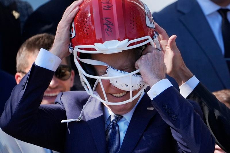 President Joe Biden, puts on a Kansas City Chiefs helmet during an event with the Super Bowl-champion Kansas City Chiefs on the South Lawn of the White House, Friday, May 31, 2024, to celebrate their championship season and victory in Super Bowl LVIII. (AP Photo/Evan Vucci)