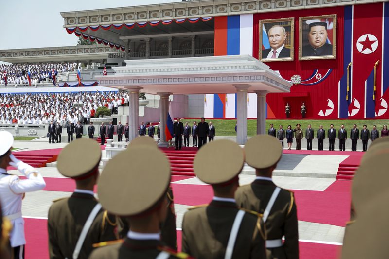 Russian President Vladimir Putin, rear left, and North Korea's leader Kim Jong Un, both are on the podium, attend the official welcome ceremony at the Kim Il Sung Square in Pyongyang, North Korea, Wednesday, June 19, 2024. (Gavriil Grigorov, Sputnik, Kremlin Pool Photo via AP)