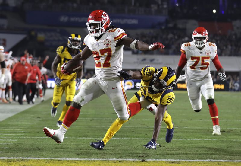 FILE - Kansas City Chiefs running back Kareem Hunt (27) scores a touchdown ahead of Los Angeles Rams free safety Lamarcus Joyner (20) as Chiefs offensive guard Cameron Erving (75) looks on during the first half of an NFL football game, Monday, Nov. 19, 2018, in Los Angeles. (AP Photo/Marcio Jose Sanchez, File)