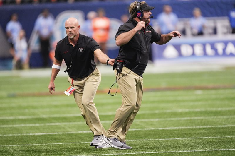 Georgia head coach Kirby Smart, right, is restrained by an assistant coach during the first half of an NCAA college football game against Clemson Aug. 31, 2024, in Atlanta. (AP Photo/John Bazemore)