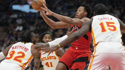 Toronto Raptors forward Scottie Barnes (4) makes a pass over Atlanta Hawks guard Wesley Matthews (32) during the first half of an NBA basketball game in Toronto, Wednesday, Dec. 13, 2023. (Frank Gunn/The Canadian Press via AP)