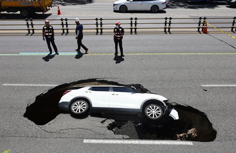 A vehicle that fell into a sinkhole is seen on a street in Seoul, South Korea, Thursday, Aug. 29, 2024. (Seo Dae-yeon/Yonhap via AP)