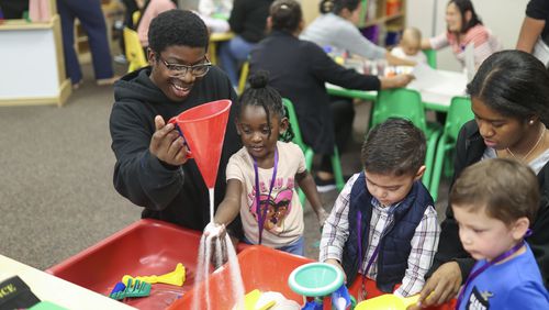 Eighth grade student Jahrian Clyde plays with 3-year-old Ariyah White at the Play 2 Learn program at Duluth Middle School, Wednesday, Nov. 8, 2023. These students are part of the teaching profession program and have an interest in a career in education. (Jason Getz / Jason.Getz@ajc.com)