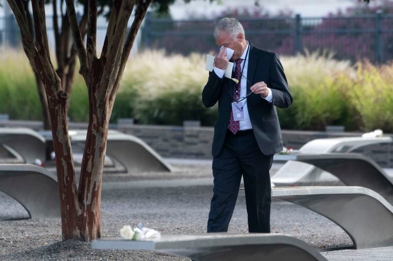 A man wipes his eyes as he walks through the 9/11 Pentagon Memorial on Wednesday, Sept. 11, 2024 in Washington. (AP Photo/Kevin Wolf)